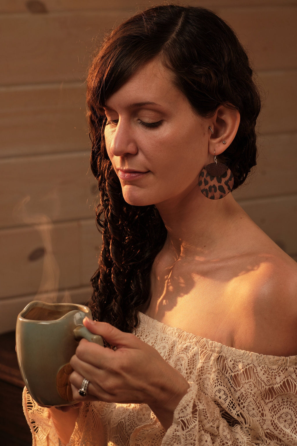 Woman holding a mug with a warm, wooden background