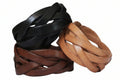 Three braided leather bracelets in black, brown, and tan on a white surface.