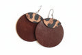 Pair of earrings with brown and leopard print design on a fluffy white surface
